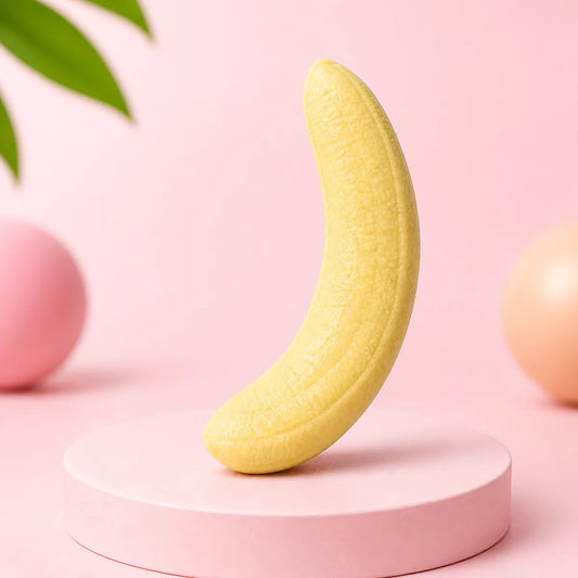 Jasnożółty gniotek squishy w kształcie banana na różowym podeście