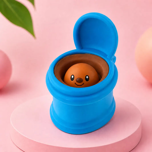 Niebieski gniotek squishy w kształcie otwartej toalety z uśmiechniętą brązową figurką w środku na różowym podeście