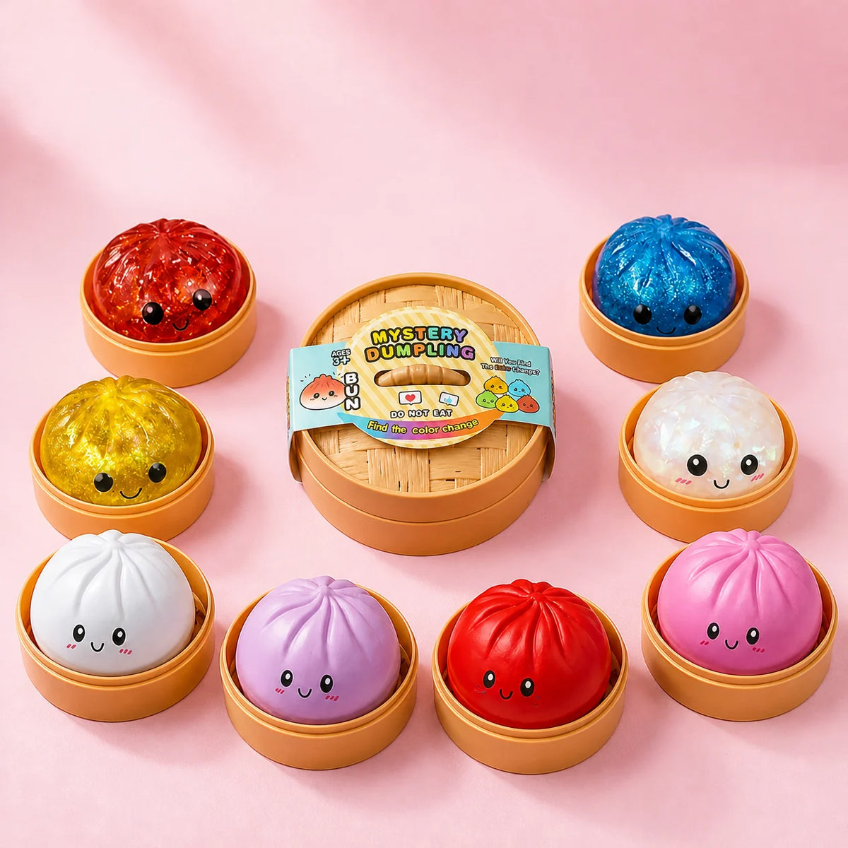 Kolorowe gniotki squishy w kształcie pierożków mantou w koszyczkach wokół pudełka Mystery Dumpling