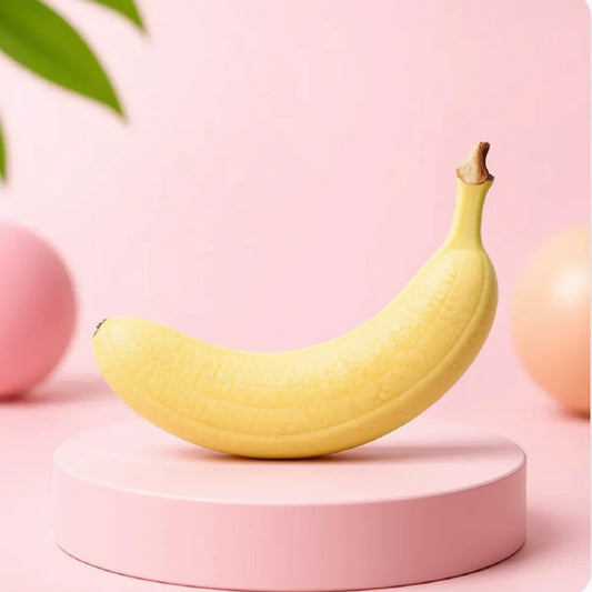 Jasnożółty gniotek squishy w kształcie banana na różowym podeście