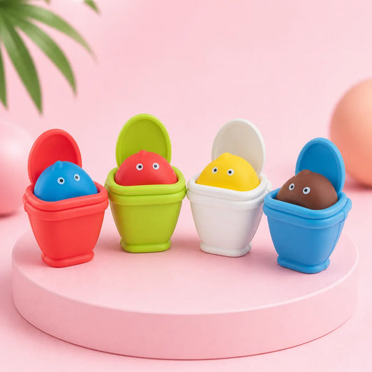 Cztery gniotki squishy w kształcie toalet: czerwona z niebieską figurką, zielona z czerwoną, biała z żółtą i niebieska z brązową na różowym podeście