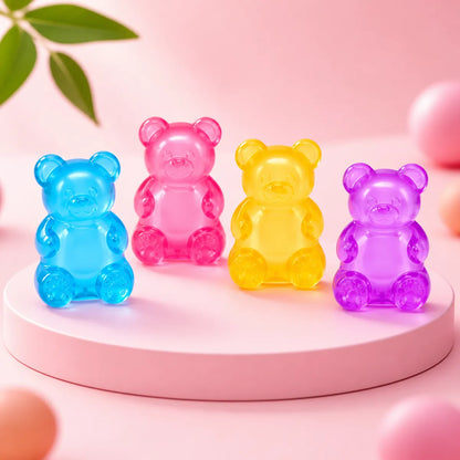Cztery przezroczyste żelowe gniotki squishy w kształcie misiów: niebieski, różowy, żółty i fioletowy na różowym podeście
