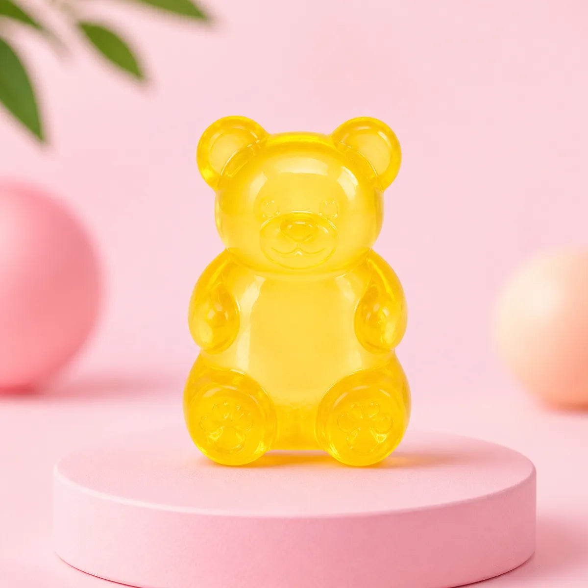 Żółty przezroczysty gniotek squishy w kształcie żelowego misia na różowym podeście