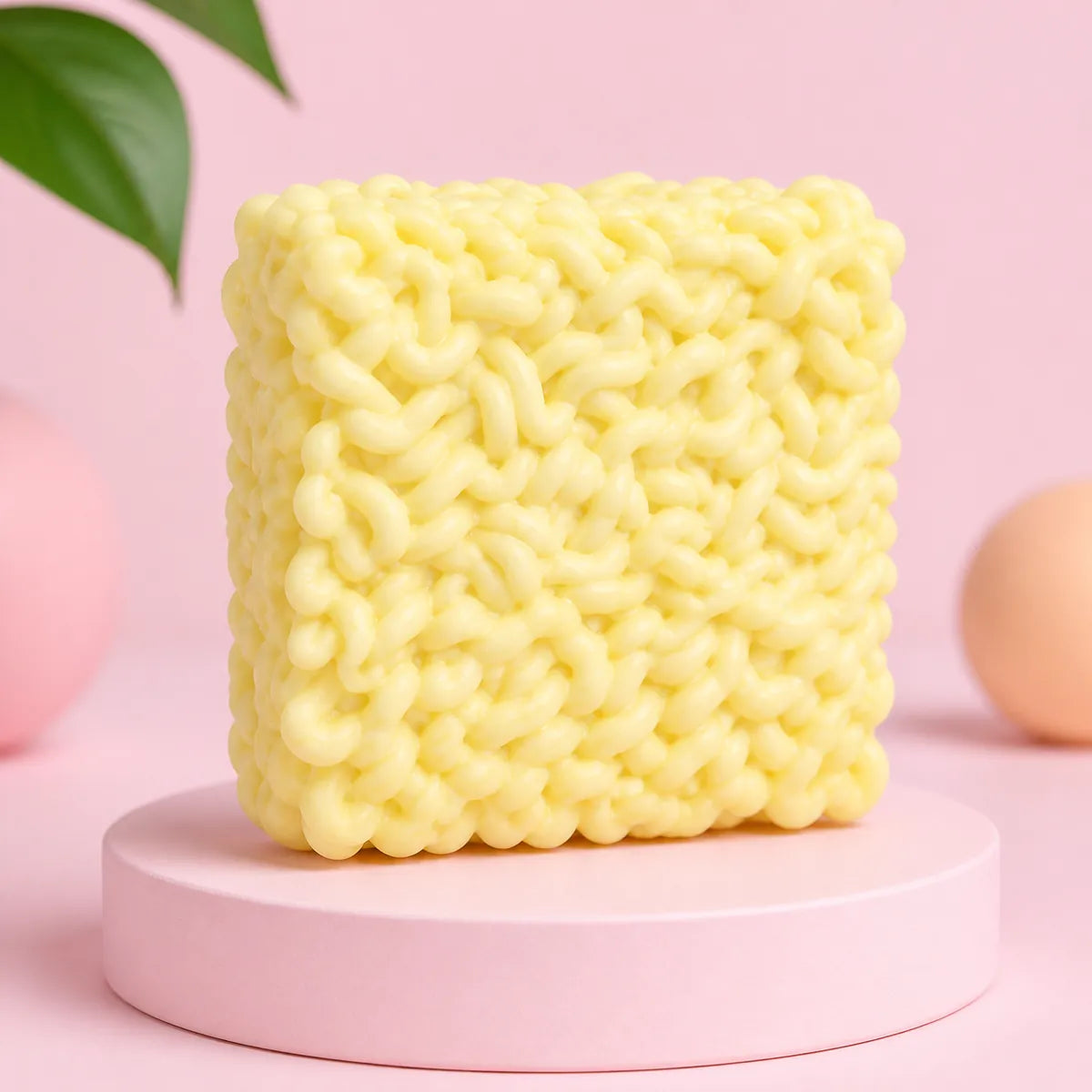 Jasnożółty gniotek squishy w kształcie kostki makaronu instant na różowym podeście