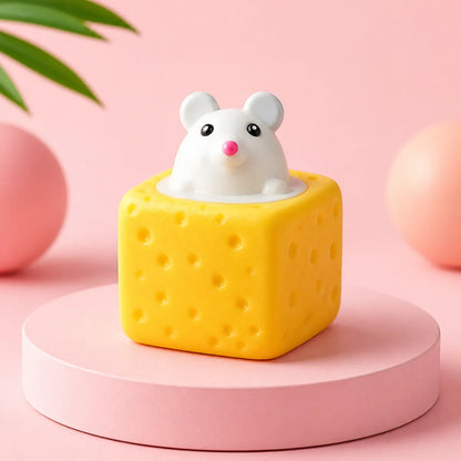 Żółty gniotek squishy w kształcie kostki sera z białą myszką wyglądającą z góry na różowym podeście